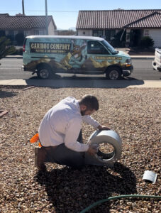 caribou comfort hvac technician working in front of branded van